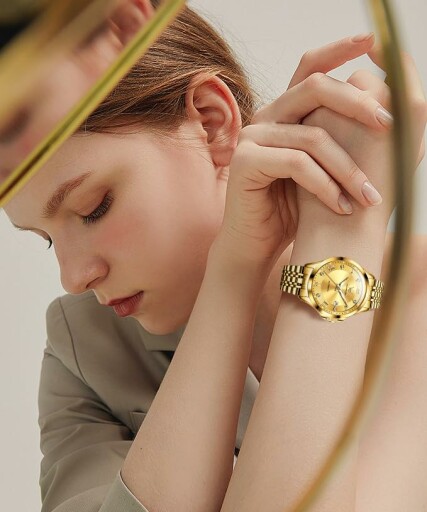 Elegant gold wristwatch with Roman numerals held in hand.