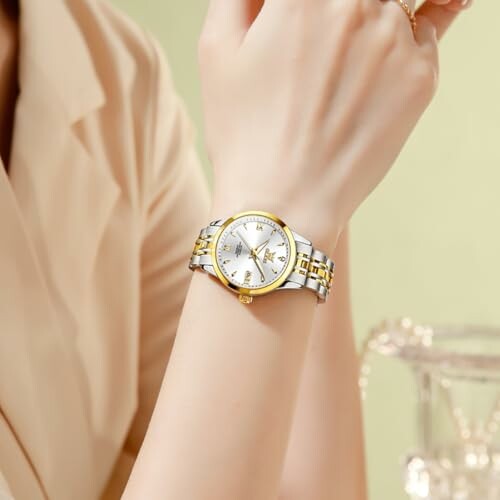 Person wearing a gold and silver wristwatch.