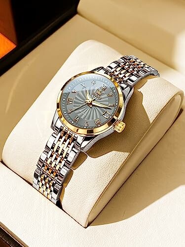 Luxury wristwatch with gold and silver bracelet in a display box.