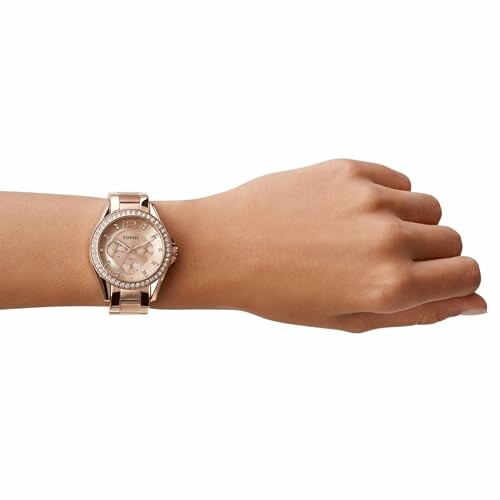 Rose gold wristwatch on a person's wrist.