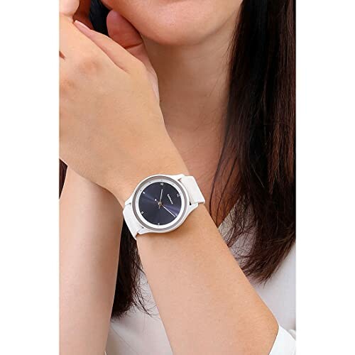 Woman wearing a white wristwatch on her left wrist.